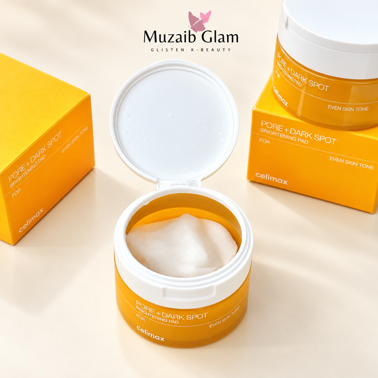 Open Celimax Pore + Dark Spot Brightening Pad jar showing toner pads beside yellow packaging on a cream background